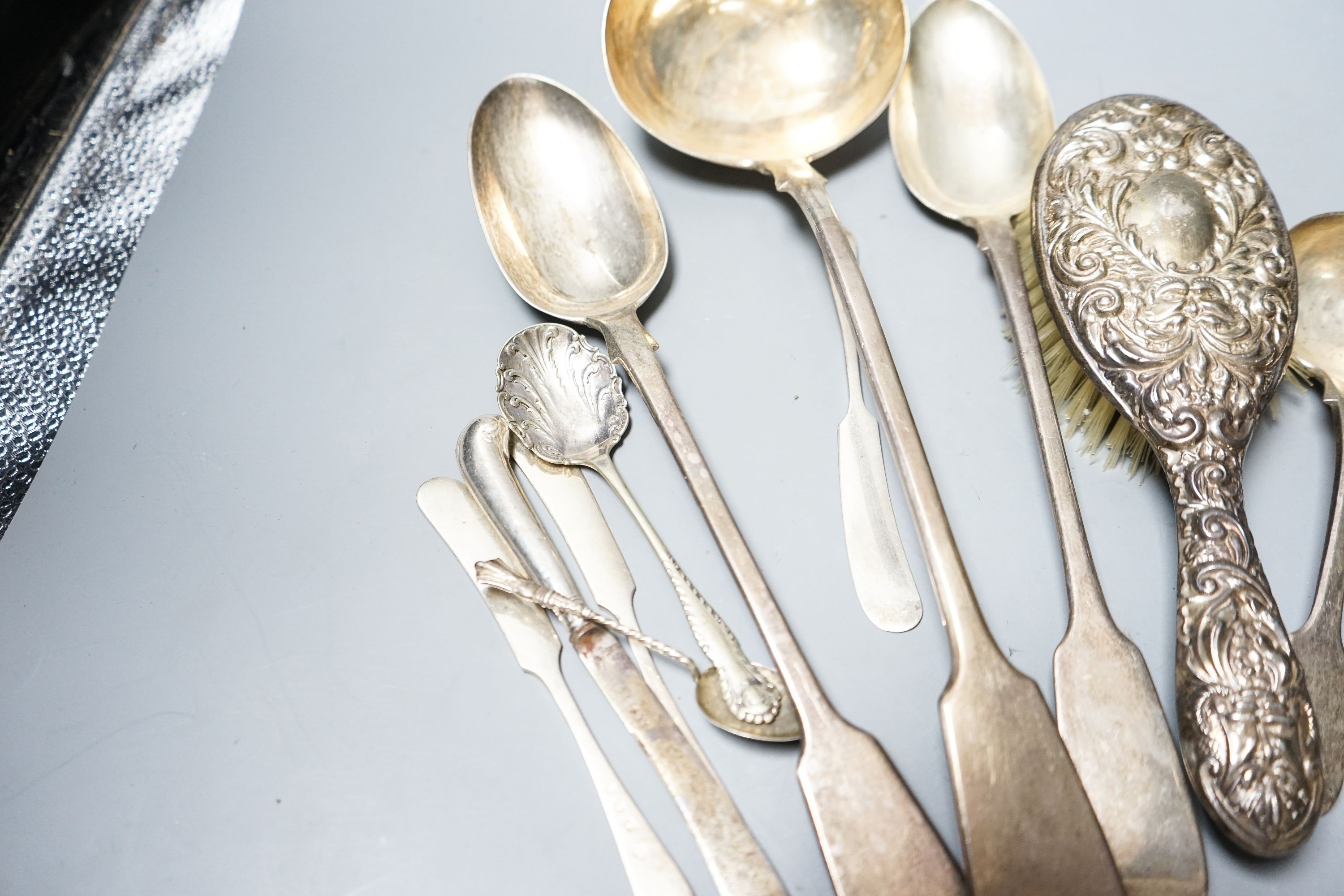 A group of silver flatware including a Victorian soup ladle and two basting spoons and three dressing table accessories, weighable silver 24oz